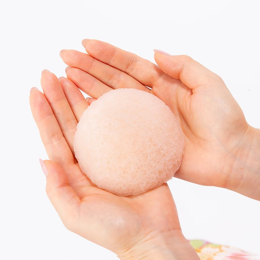Cherry blossom konjac face sponge held in two hands