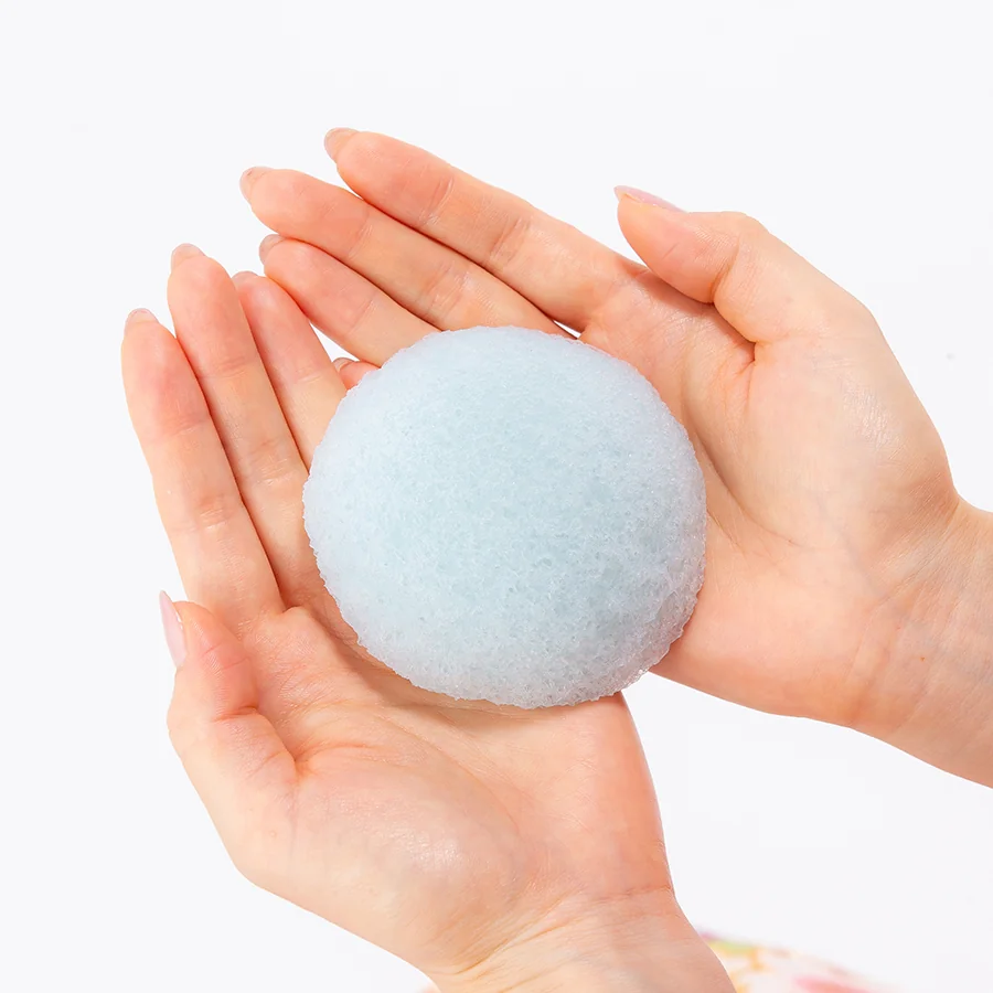 Wild mint konjac face sponge held in two hands