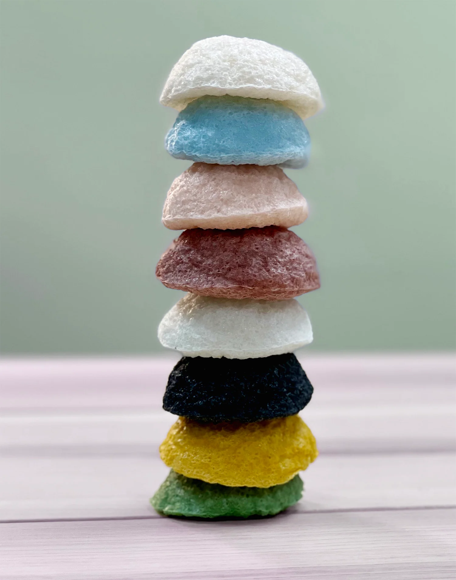 Eight colours of Yamamoto Farm konjac face sponges stacked in a column