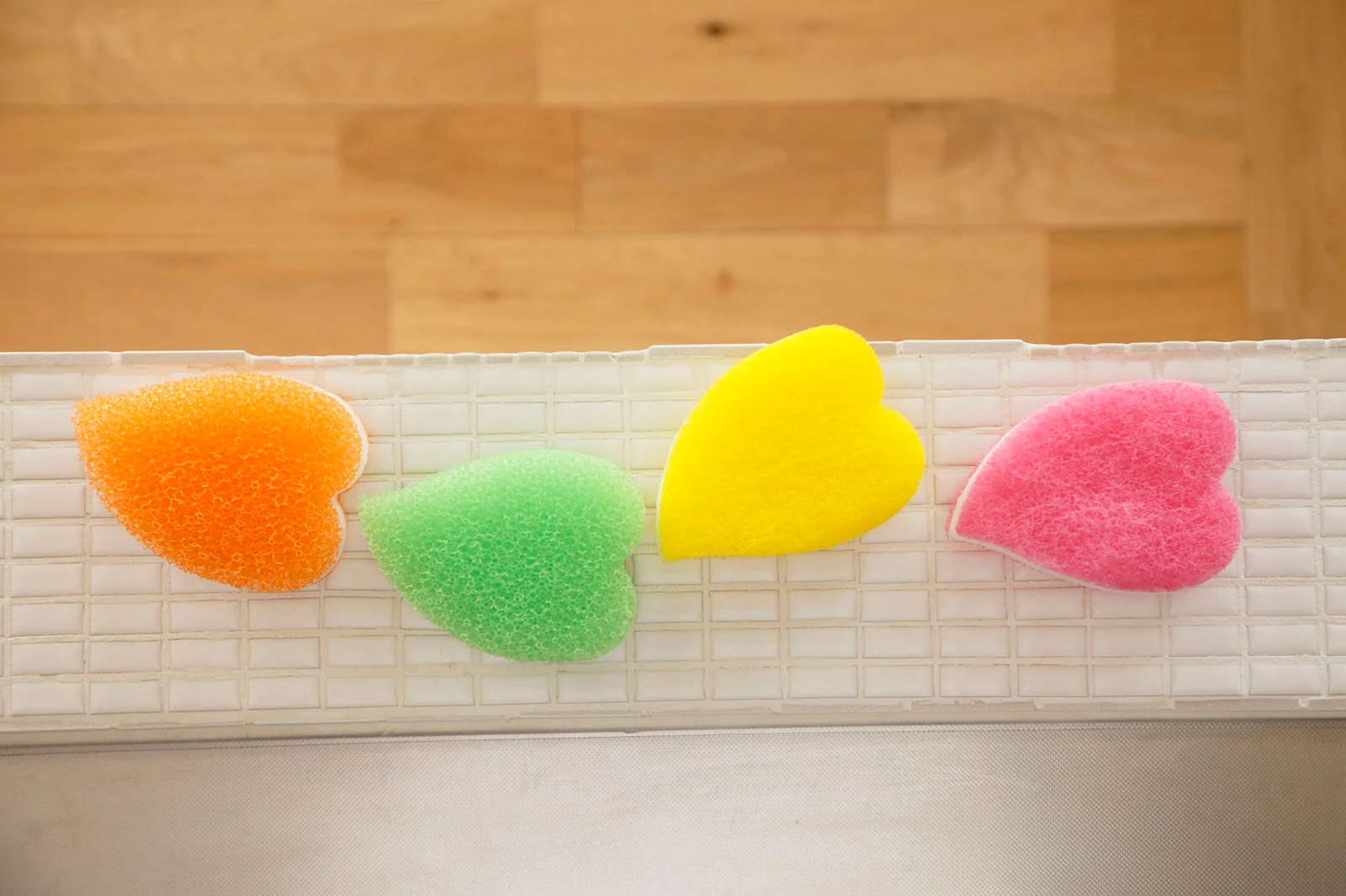 Colourful AISEN kitchen sponges displayed beside a sink