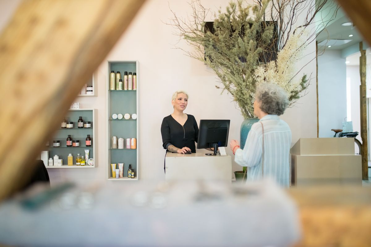 Hairdresser speaking with a customer at a salon reception